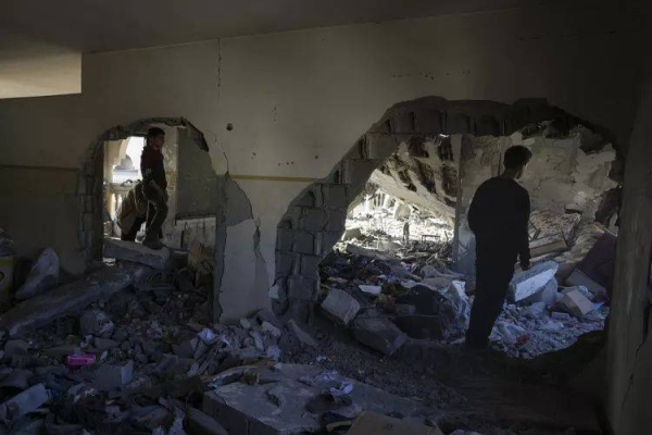 Women mourn near the bodies of victims killed in Israeli bombardment as they lie wrapped in blankets at the Ahli Arab hospital, in Gaza on Tuesday.