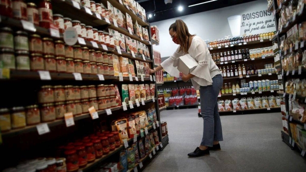 An employee restocks a sales at a grocery store in Bretigny-sur-Orge, near Paris