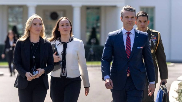 Defense Secretary Pete Hegseth, second from right, walks outside the White House