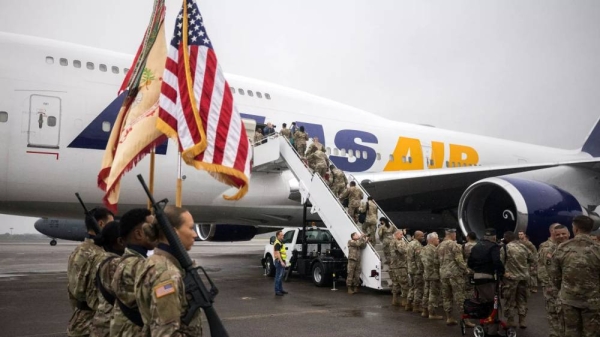 A group of soldiers with the US Army's 87th Division Sustainment Support Battalion boards a chartered plane during their deployment to Europe, 11 March, 2022