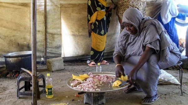 A Sudanese woman cooks at a camp for displaced people in Port Sudan on Tuesday