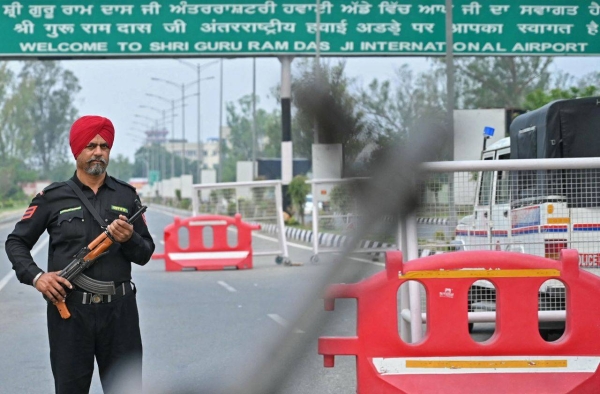 Police guard the road to the Shri Guru Ram Das Ji International Airport on the outskirts of Amritsar, India, on Wednesday.