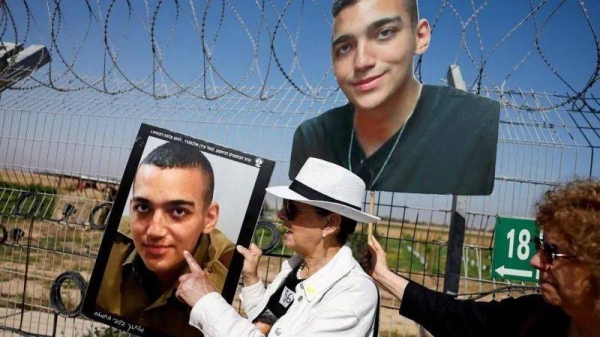Edan Alexander's grandmother holds a photo of him, as she called for his release again last month
