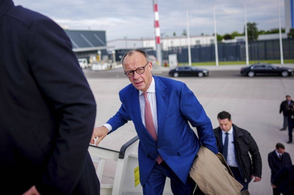 German Chancellor Friedrich Merz, center, embarks on a flight at Berlin's Schönefeld Airport on Friday, en route to Tirana for the European Political Community Summit.