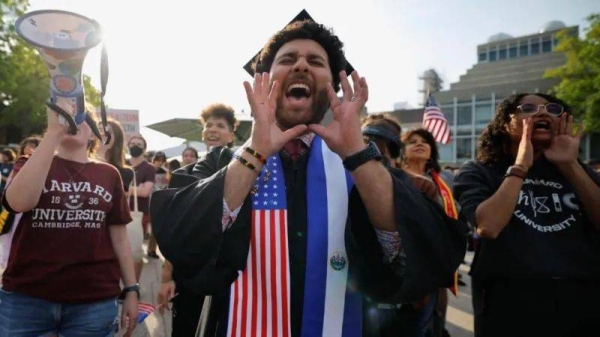 A person wears a stole with the flags of US and El Salvador as members of the Harvard community take part in a rally to support and celebrate the school's international students at Harvard