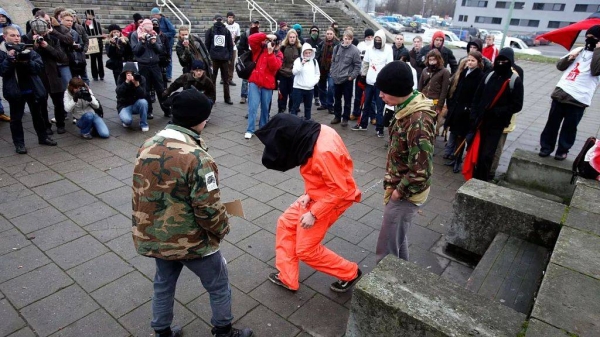Protesters, including one wearing a Guantanamo Bay style prison jumpsuit, gather during the visit of US President George W. Bush to Tallinn, Estonia (File photo)