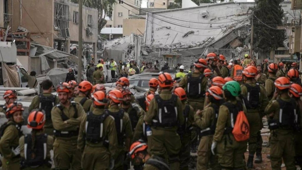 Rescue workers, police and military inspect the site where an Iranian missile struck in Bnei Brak, near Tel Aviv, Israel, Monday, June 16, 2025