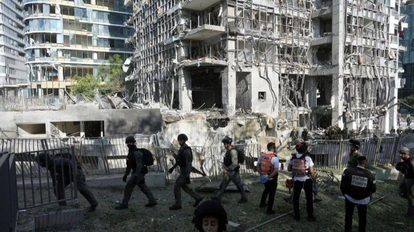 Rescue workers and military personnel inspect the site of a direct hit from an Iranian missile strike in Ramat Gan, Israel, Thursday, June 19, 2025