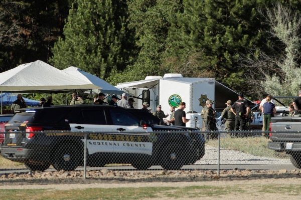 Law enforcement officers gather after multiple firefighters were attacked when responding to a fire in the Canfield Mountain area outside Coeur d’Alene, Idaho, on Sunday.