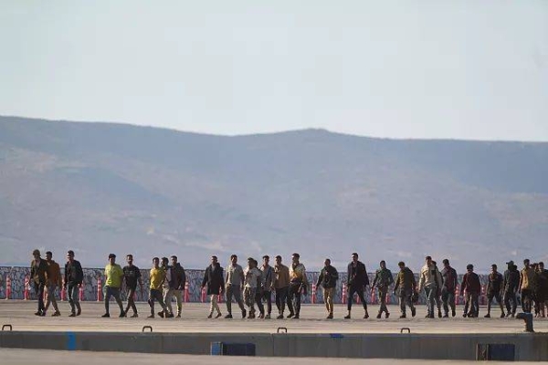 Migrants rescued south of Crete walk after their arrival at the the port of Lavrio, 10 July, 2025