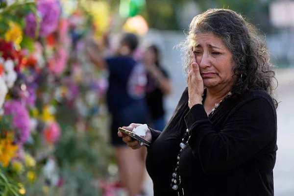 Olivia Montanez wipes away tears as she visits a memorial for flood victims on Thursday, July 10, 2025, in Kerrville, Texas