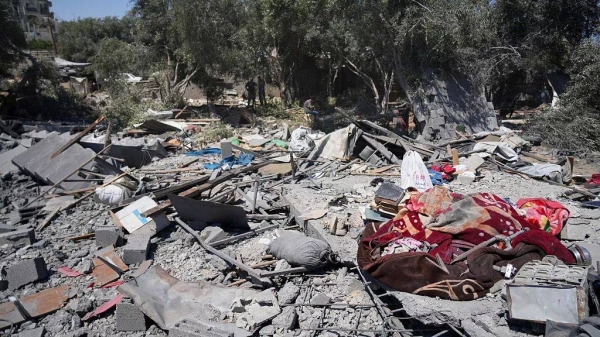 Palestinians inspect the site of an Israeli army strike on a house belonging to the Al-Arabid family killing at least 9 people, in Al-Zawida, central Gaza Strip, Sunday, July 13