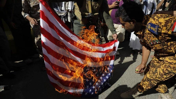 Houthi supporters burn a US flag during a military march marking the anniversary of Yemeni unity in Sanaa, 22 May, 2024
