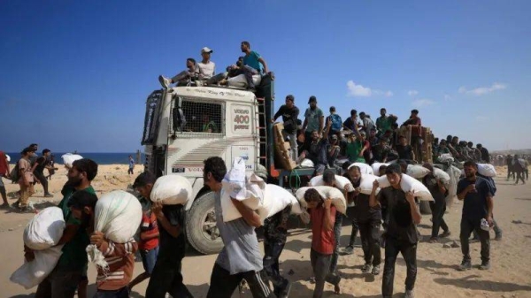 Palestinians pictured carrying aid supplies in Beit Lahia, northern Gaza, on Sunday