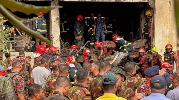 Firemen check the wreckage of a Bangladesh Air Force training aircraft that crashed onto a school campus in Dhaka, 21 July, 2025