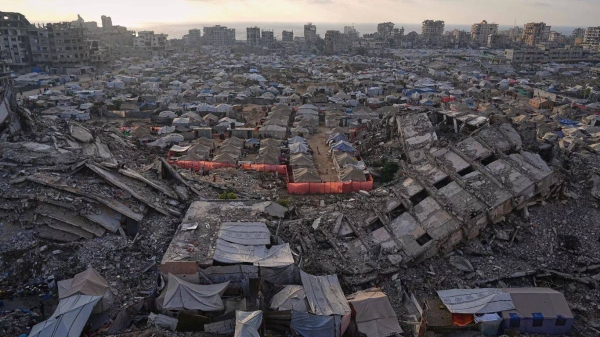 A tent camp for displaced Palestinians stretches among the ruins of buildings destroyed by Israeli bombardments in west of Gaza City, 21 June 2025