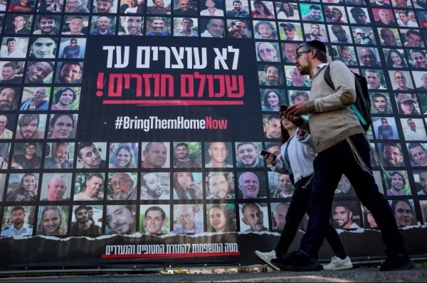 On January 16, people in Jerusalem walk past posters of hostages kidnapped during the deadly October 7, 2023 attack by Hamas.