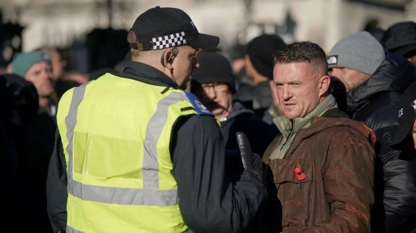 Far-right figurehead Tommy Robinson speaks to a police officer in London, 11 November 2023