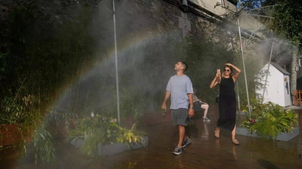 People cool off under showers at Paris Plage along the Seine river in Paris, 10 August 2025