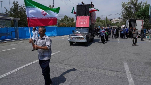 A worshipper holds an Iranian flag at the start of an anti-U.S. and anti-Israeli protest after the Friday prayers in Tehran, Iran, Friday, July 25, 2025