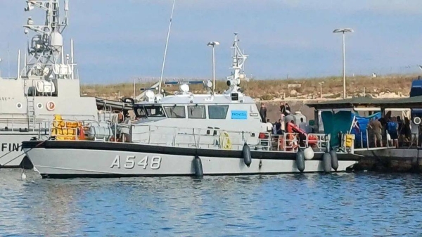 Migrants disembark from a boat that rescued them after two vessels sank off the coast of Italy's Lampedusa island