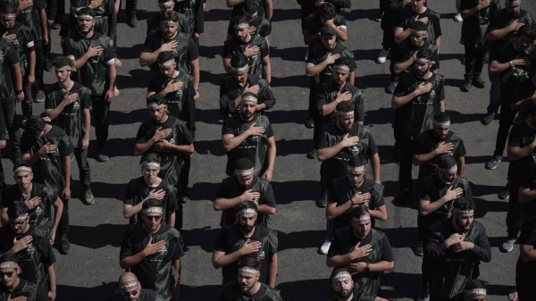 Hezbollah supporters beat their chests as they march in Beirut, 6 July 2025
