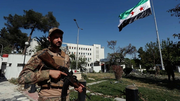 Syrian soldiers raise the Syrian national flag in front of the Defence Ministry building in Damascus, 19 July 2025
