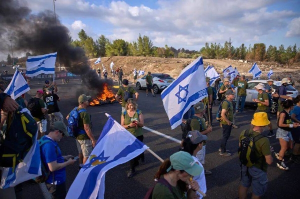 Demonstrators block a road during a protest near Jerusalem calling for the Israeli government to reverse its decision to take over Gaza City and other areas in the Gaza Strip, on Sunday