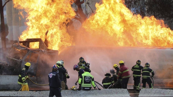 Firefighters spray hoses at a gas tanker that exploded under a highway overpass in Mexico City, on September 10, 2025.