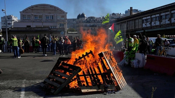 Workers gather next wooden pallets on fire at the Gare de Lyon train station during a protest called by major trade unions to oppose budget cuts, in Paris, 18 September 2025