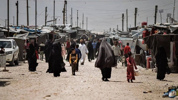 Family members of suspected Islamic State group fighters walk at al-Hol camp in Syria, 8 May, 2024