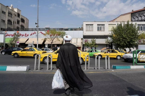 A man crosses the Enqelab-e-Eslami (Islamic Revolution) street, in Tehran, Iran, Saturday, Sept. 27, 2025