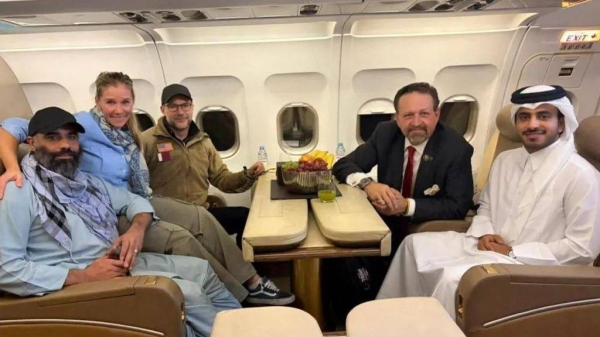Amir Amiry (far left) is photographed with US hostage envoy Adam Boehler and a Qatari diplomat on a plane from Kabul