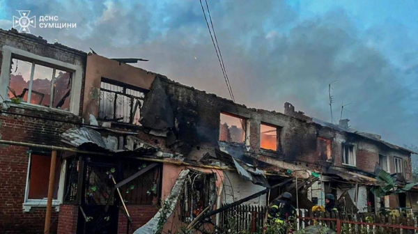 Ukrainian firefighters tackle a blaze at a house destroyed in a Russian drone attack in the village of Chernechchyna